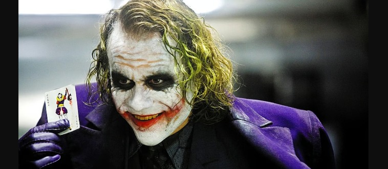 Heath Ledger playing the Joker in a violet tuxedo, emerald hair, and jagged grin. What film stars this baddie?